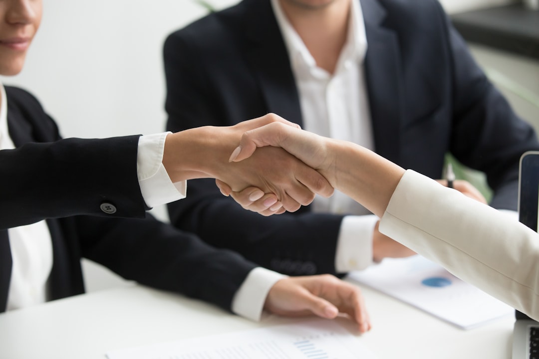 Acceuil two-people-shaking-hands-in-front-of-a-laptop-xeq8xewb4q